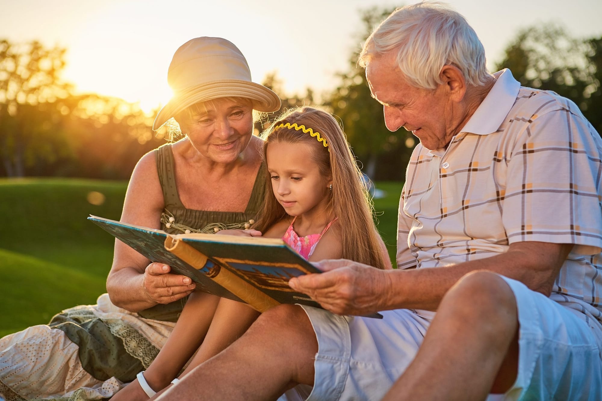 Girl,With,Grandparents,,Photo,Album.,People,Looking,At,Photos,Outdoors.